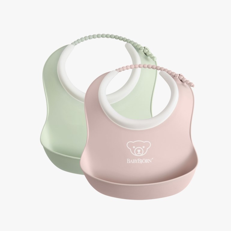 Rosa og lysgrønne smekker i silikon til baby, med justerbare perlebånd og oppsamlingslommer.