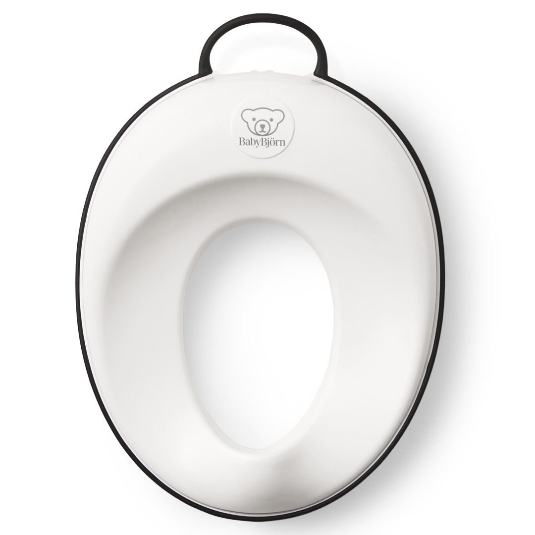 Hvit toalettreningssete for babyer med svart kant og håndtak, ovenfra.