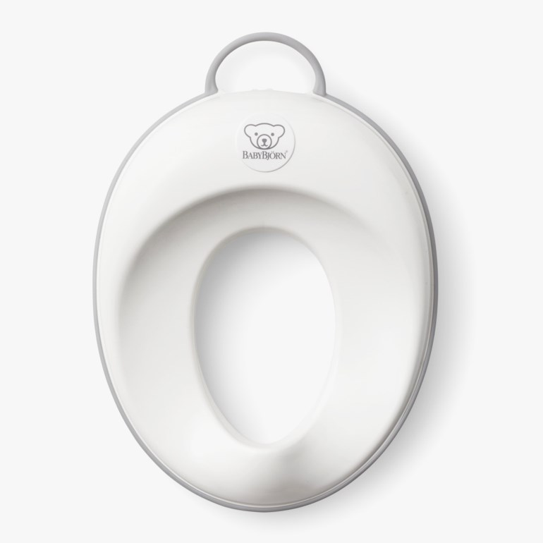 Hvit og grå babypottetrener med håndtak på toppen, sett ovenfra.