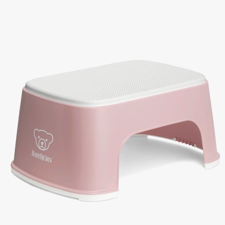 En rosa barneskammel med en hvit teksturert toppflate og hvit kant langs bunnen.