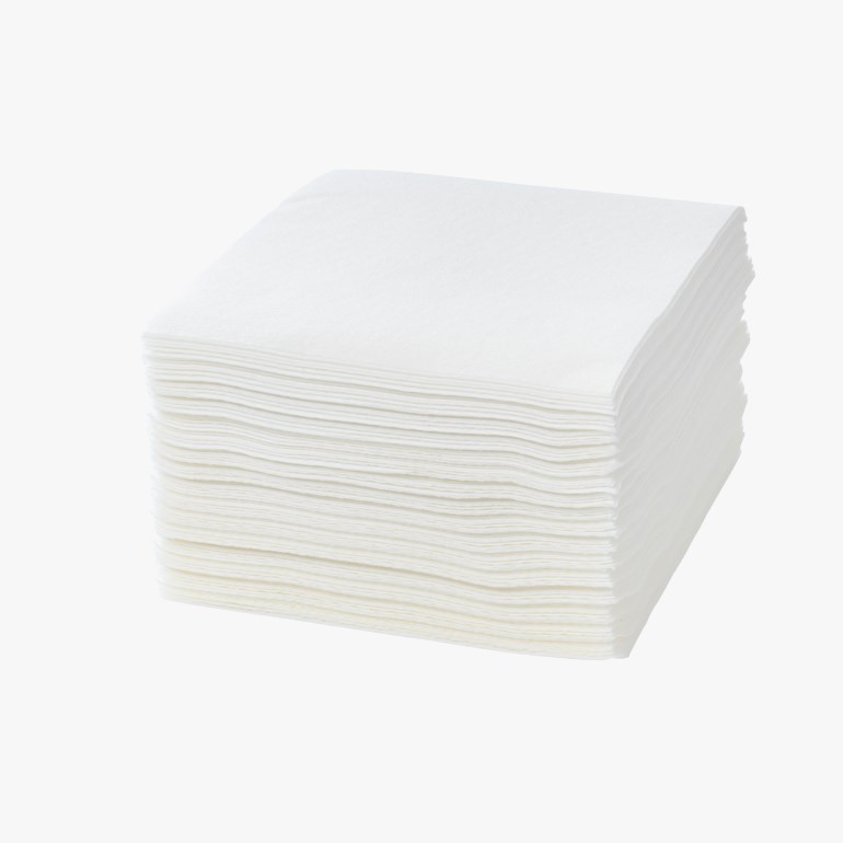 En stabel hvite firkantede papirservietter.