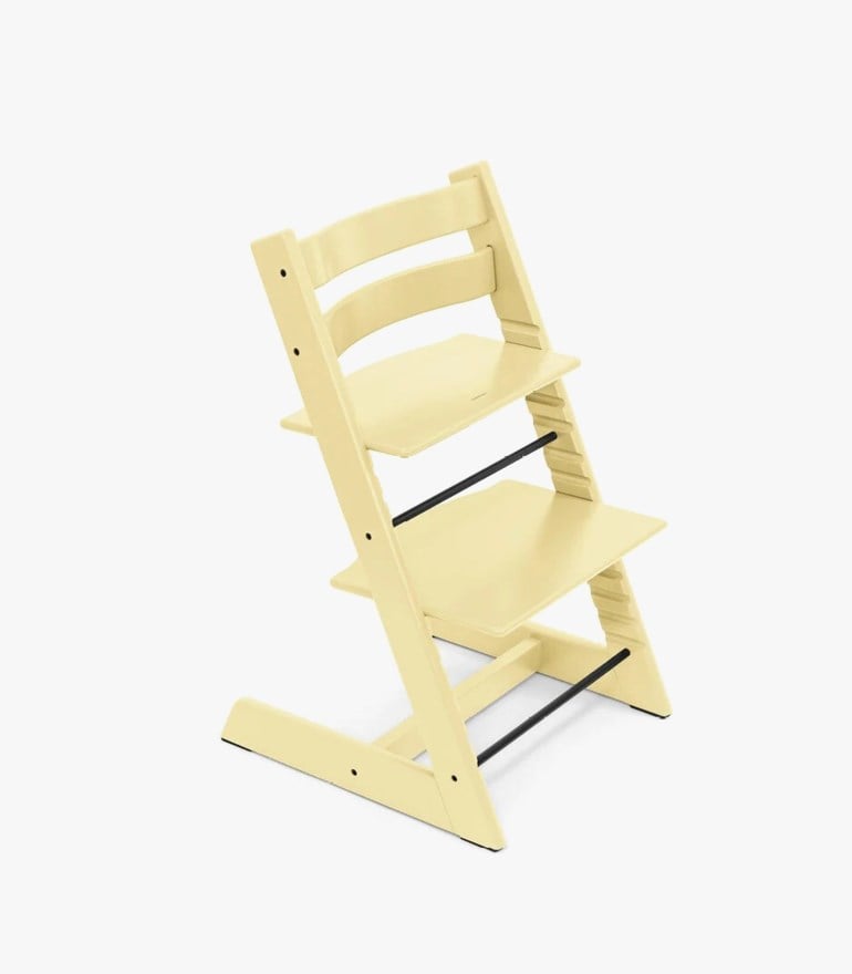 Lys gul justerbar barnestol i tre med svarte metallstenger, skrått sett.