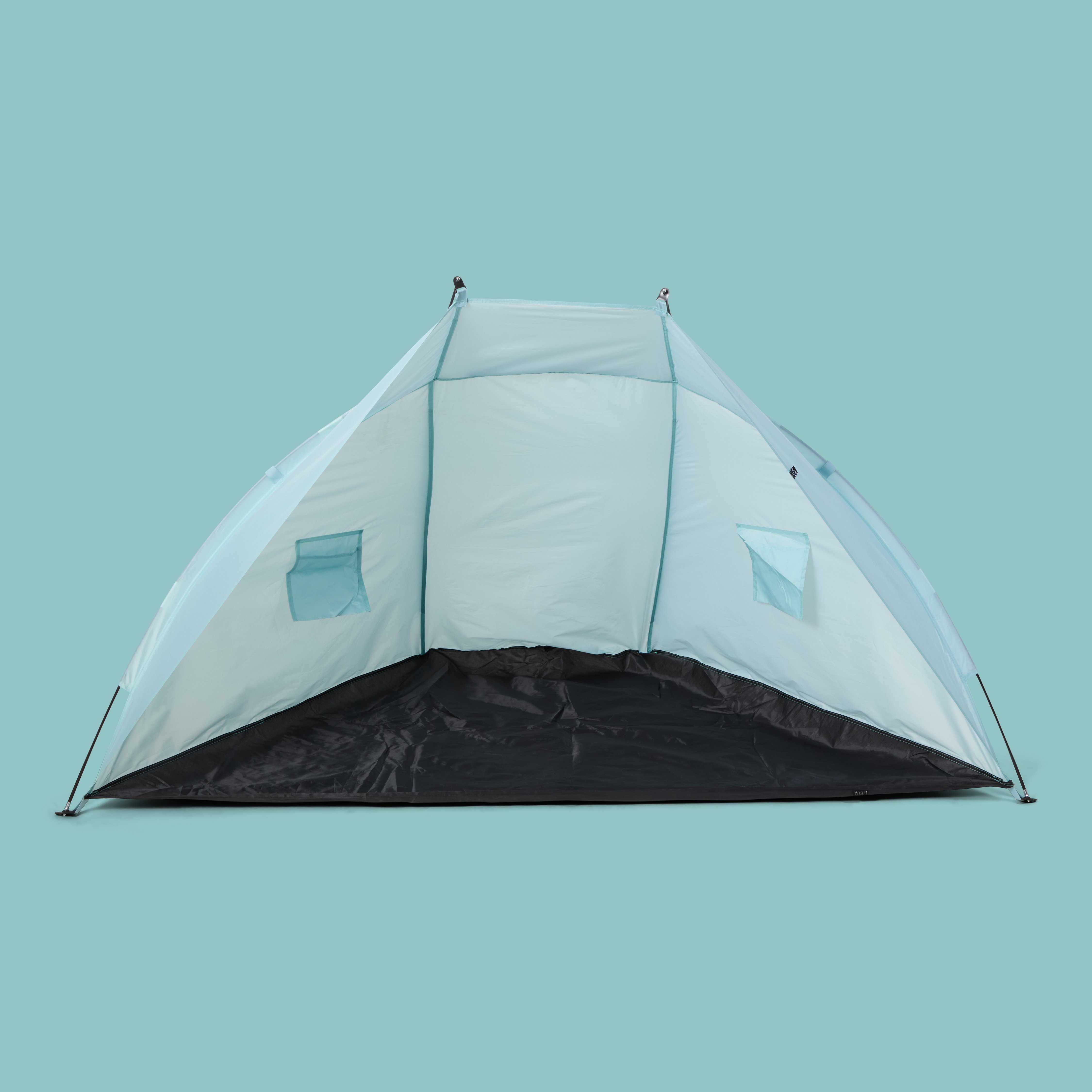 Et lyseblått og svart pop-up strandtelt med to nettingsvinduer mot en ensfarget bakgrunn.