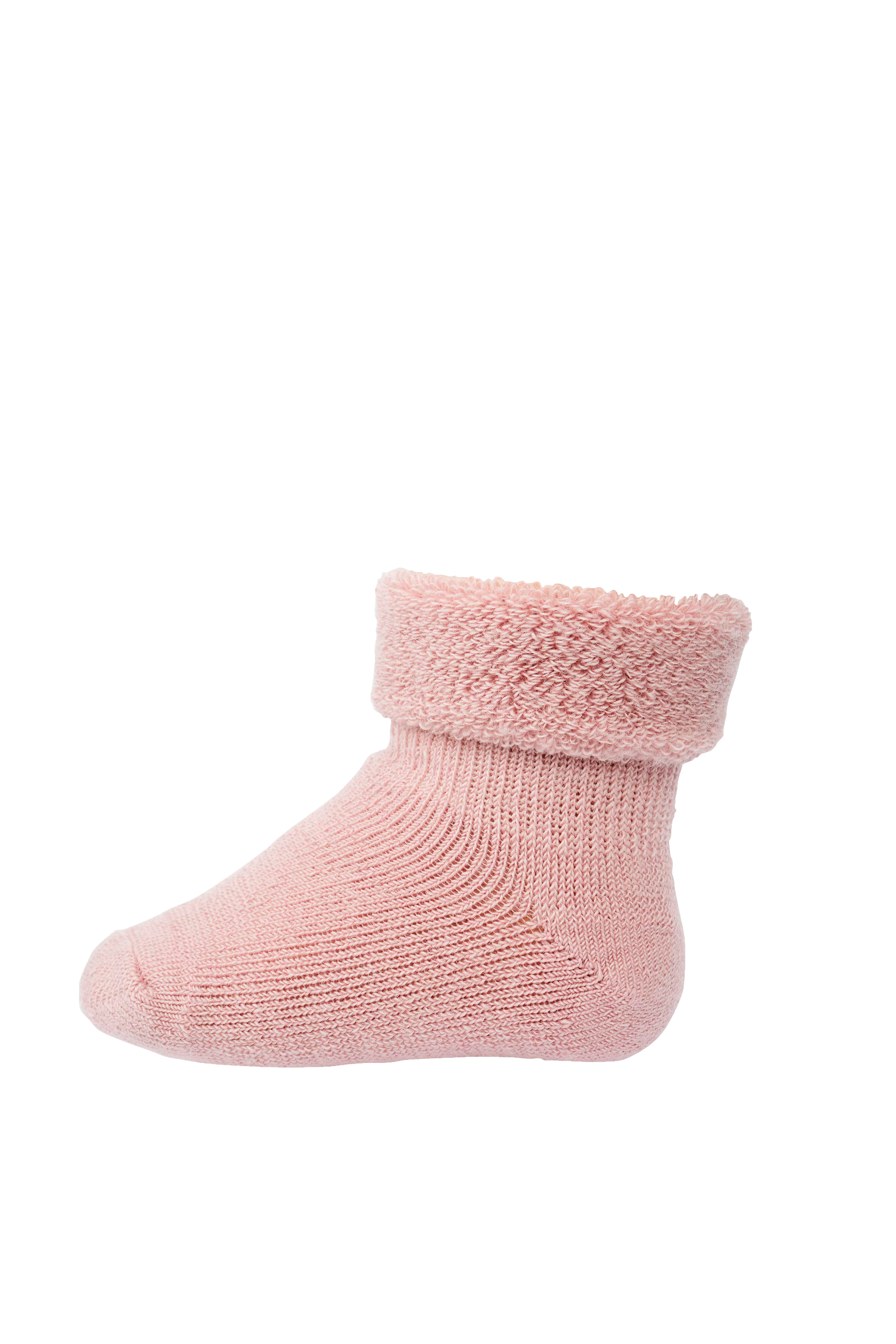 En rosa strikket babystrømpe med en myk, lodden mansjett, sett fra siden.