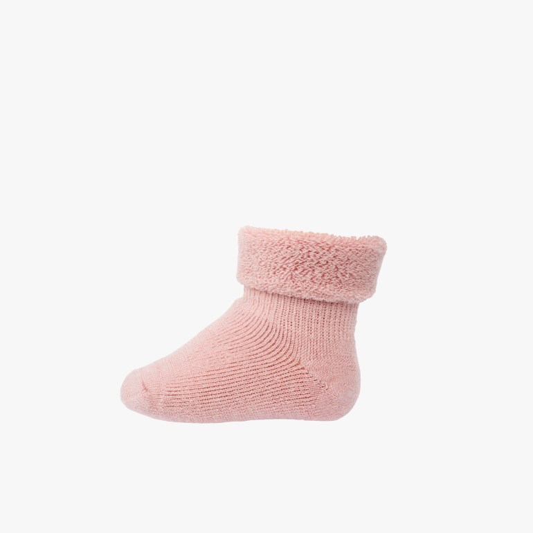 En rosa strikket babystrømpe med en myk, lodden mansjett, sett fra siden.