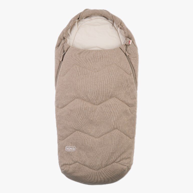 Beige vattert babyvognpose med kremfarget fôr og glidelåser på sidene, med sikksakkmønster foran.