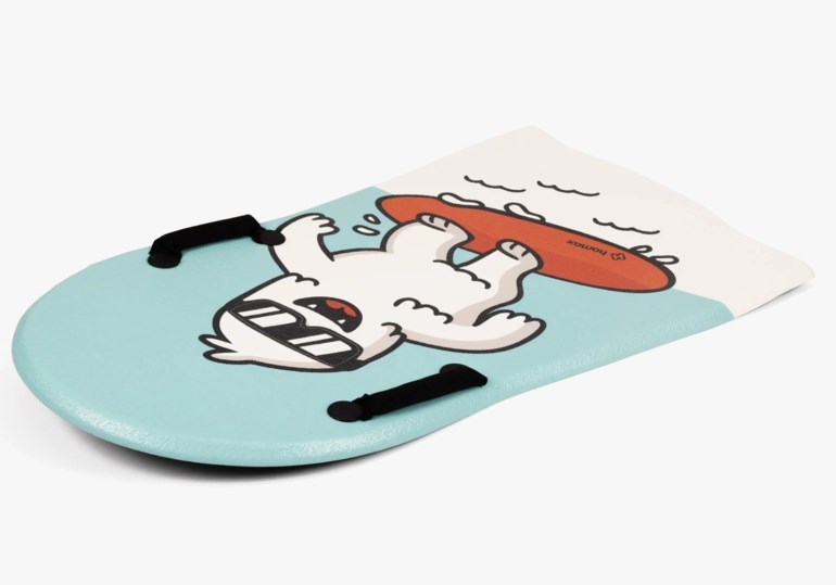 Blå og hvit snøakebrett med en tegneserie-yeti på et rødt surfebrett og to svarte håndtak.
