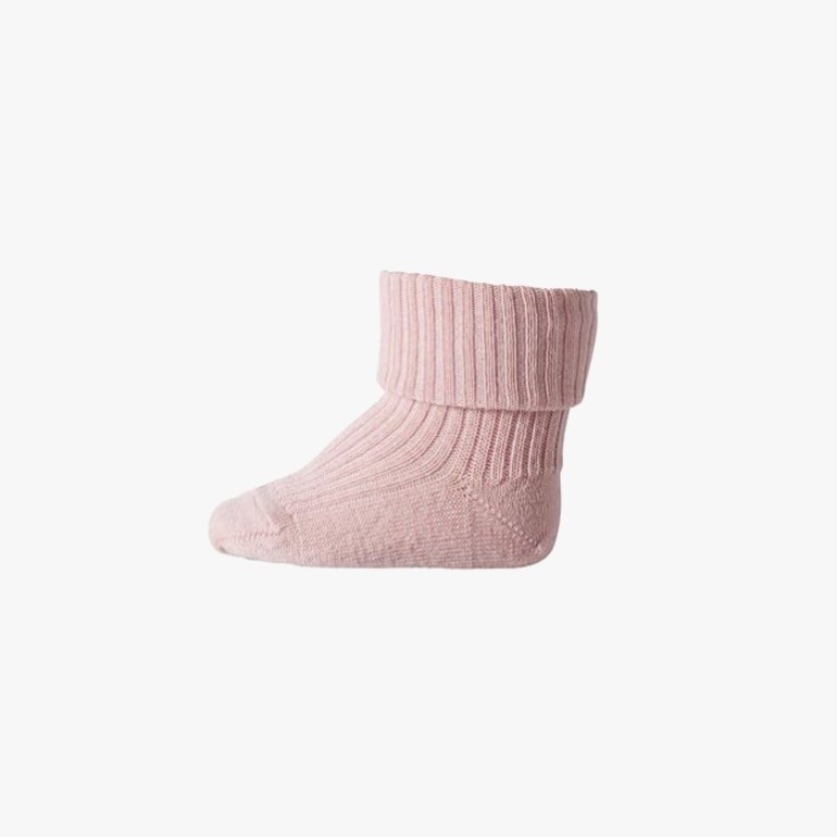 Sidebilde av en lys rosa strikket babysokk med ribbet, brettet mansjett.