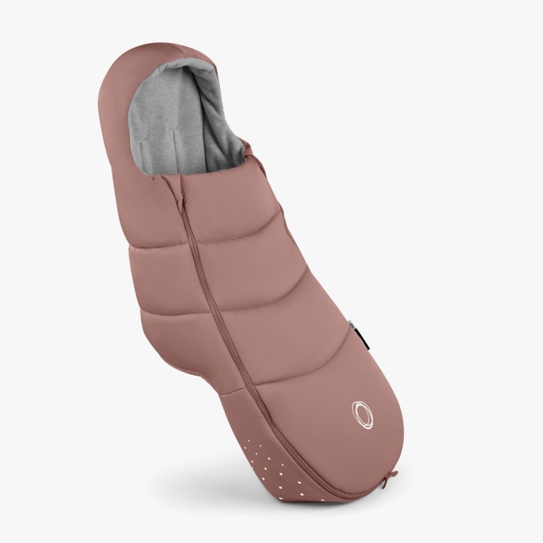 Støvrosa polstret babyvognpose med grått fôr, hel glidelås og hvite prikkdetaljer.