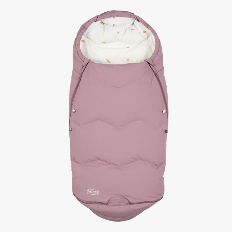 En dempet rosa vattert babyvognpose med lyst mønstret for, glidelåser i sidene og trykknapper.