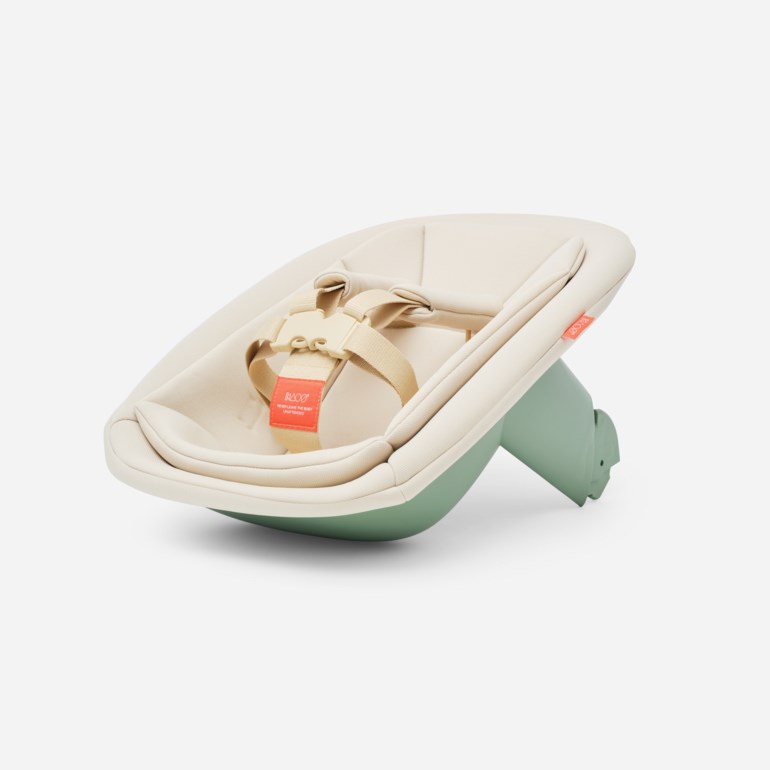 Beige babygynge med en lysegrønn base og en beige sikkerhetssele med en rød etikett.