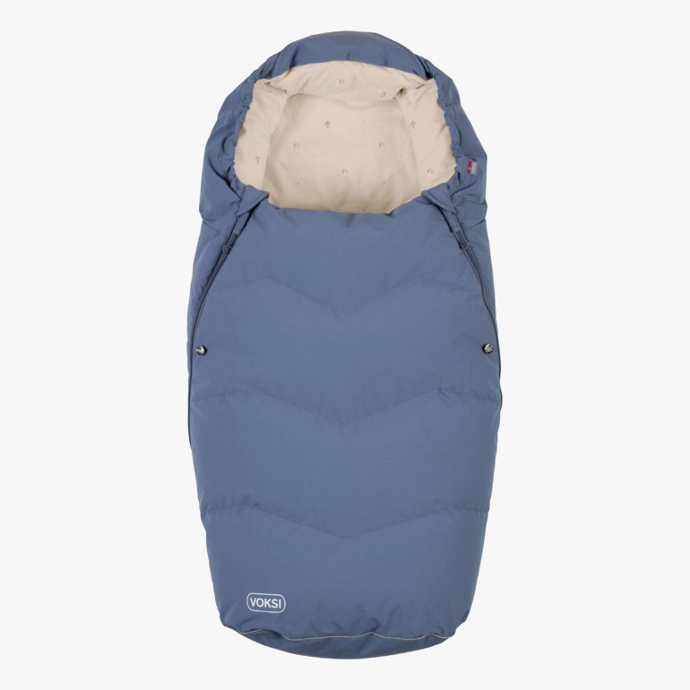 Blå babysovepose med sikksakk-quilting og lyst beige mønstret fôr, forfra.