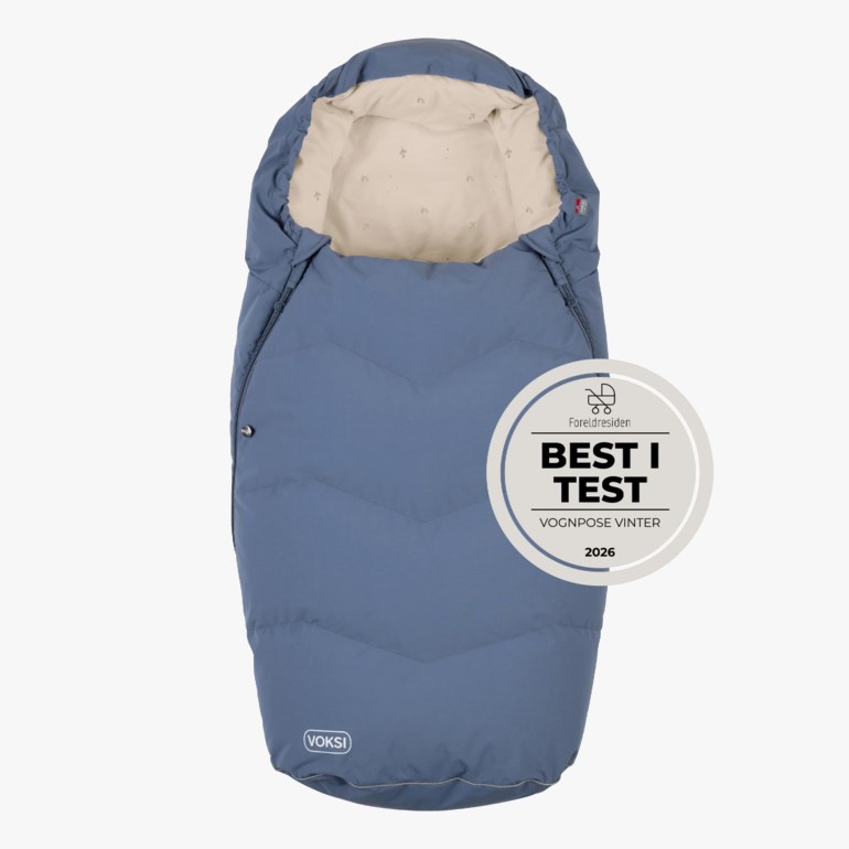 Blå quiltet vognpose med lys beige innside og 'Best i Test'-utmerkelse.