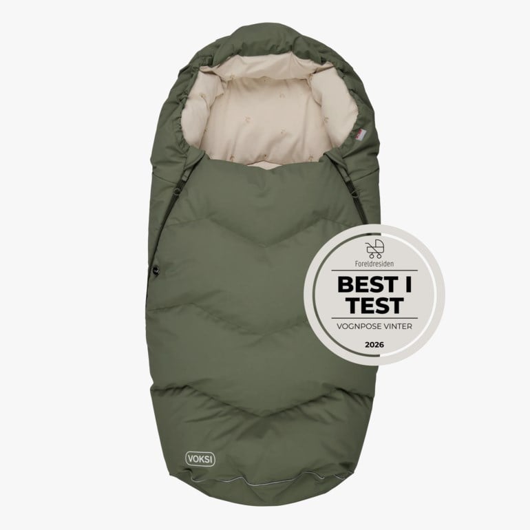 Grønn vattert babyvognpose med lyst beige mønstret fôr og en fremtredende 'BEST I TEST'-pris.