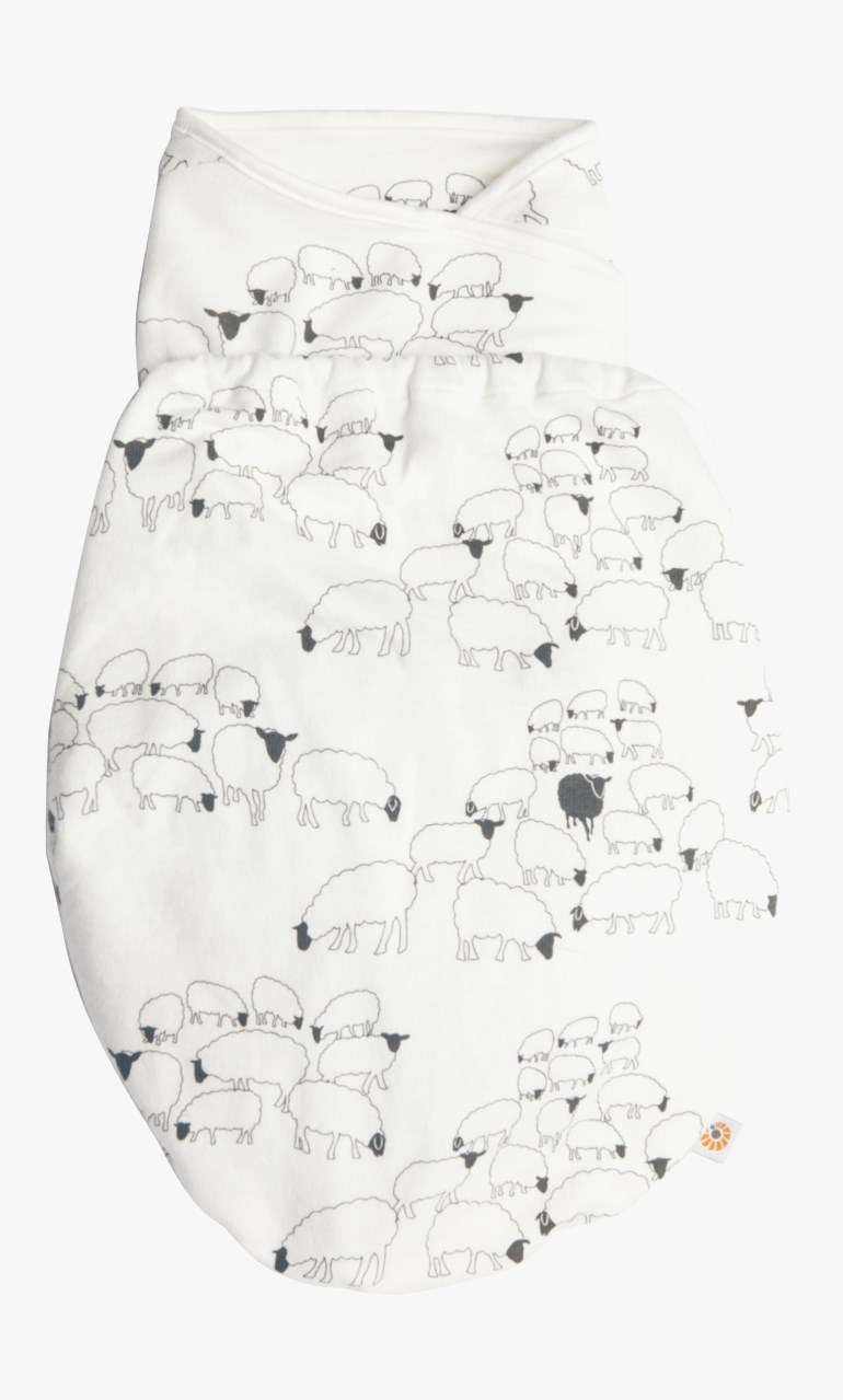 Hvit babyswaddle med heldekkende mønster av svarte og hvite sauer, med en svart sau.
