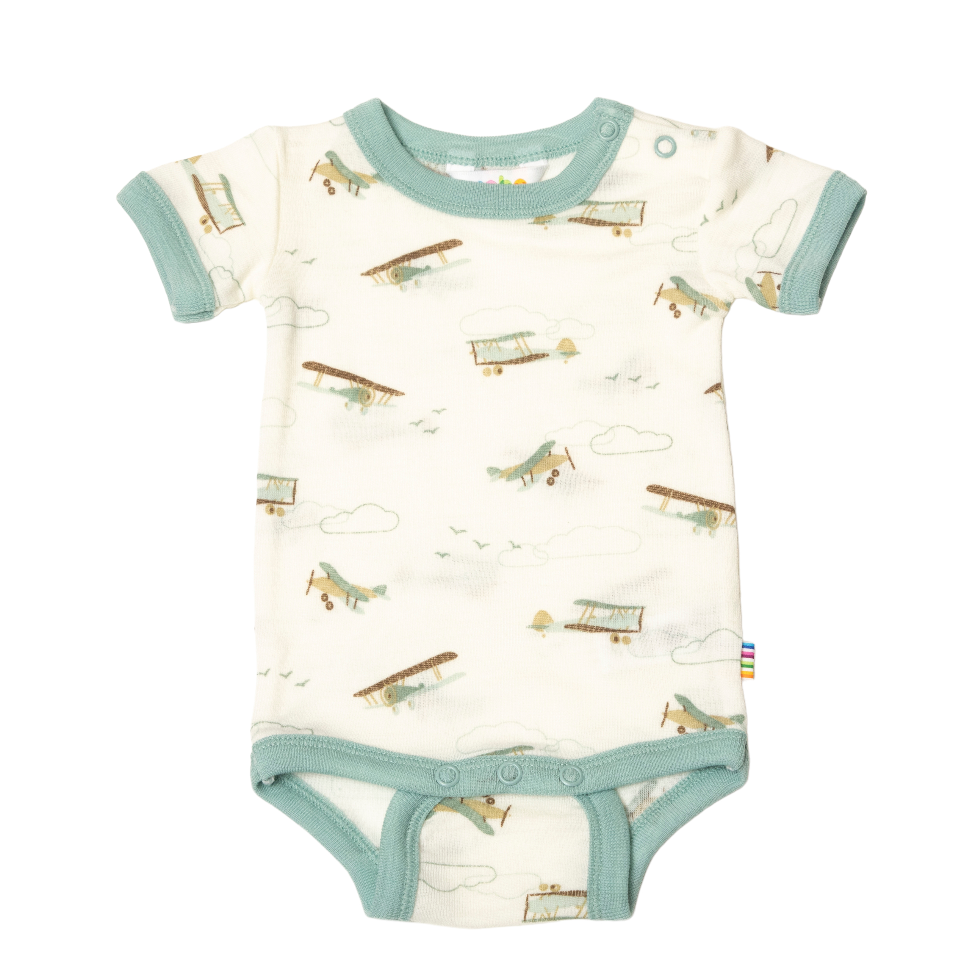 Baby kortermet offwhite body med grønn kant, flymønster og trykknapper, forfra.