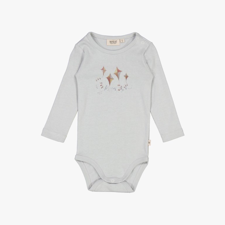 Frontbilde av en lyseblå babybody med lange ermer, fargerikt drageprint og trykknapper.