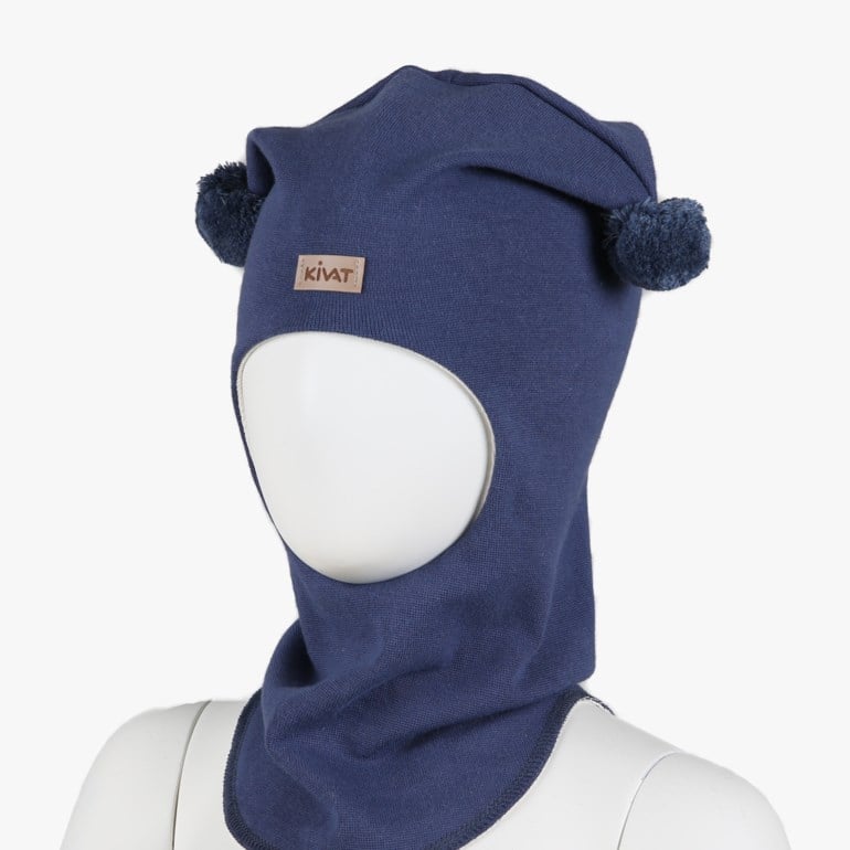 Mørkeblå balaklava for barn med to dusker og oval ansiktsåpning, sett forfra på utstillingsdukke.