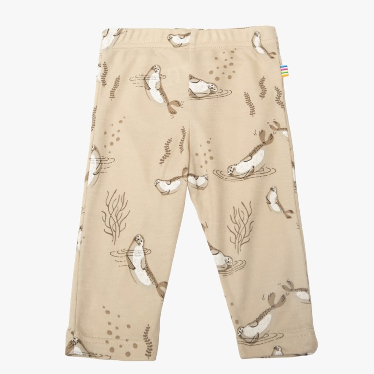 Barneleggings i beige med et heldekkende trykk av seler og planter, forfra.