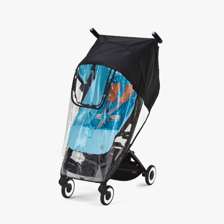 Barnevogn med sort ramme, lyseblå sittepute og sort kalesje, dekket av et gjennomsiktig regntrekk.