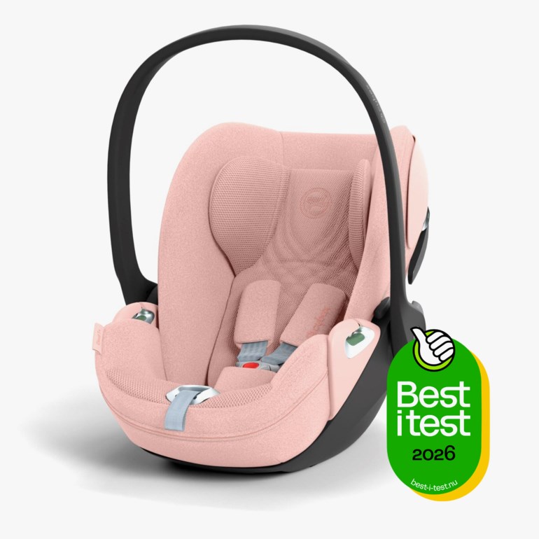 Rosa babybilstol med svart håndtak, svart base og grå sikkerhetssele.