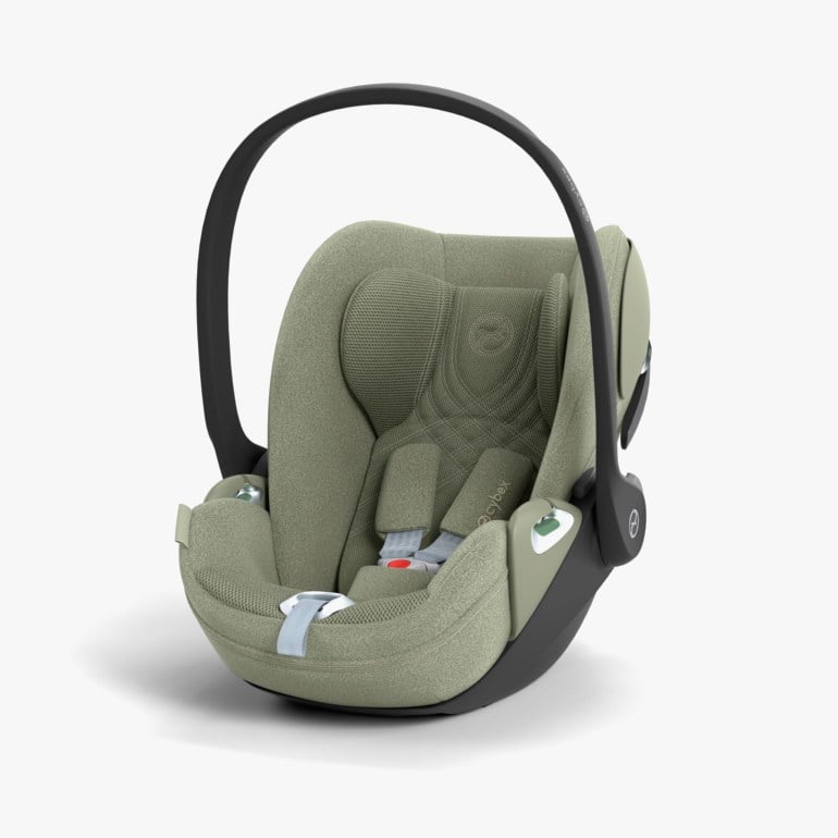 En salviegrønn babystol med svart håndtak og lyseblå sikkerhetsseler, presentert fra en frontside.