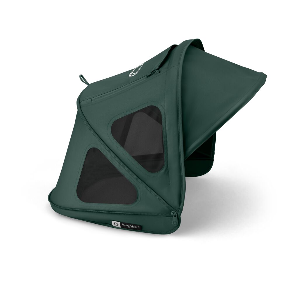 Mørkegrønn barnevognskalesje med trekantede nettingvinduer og glidelås.