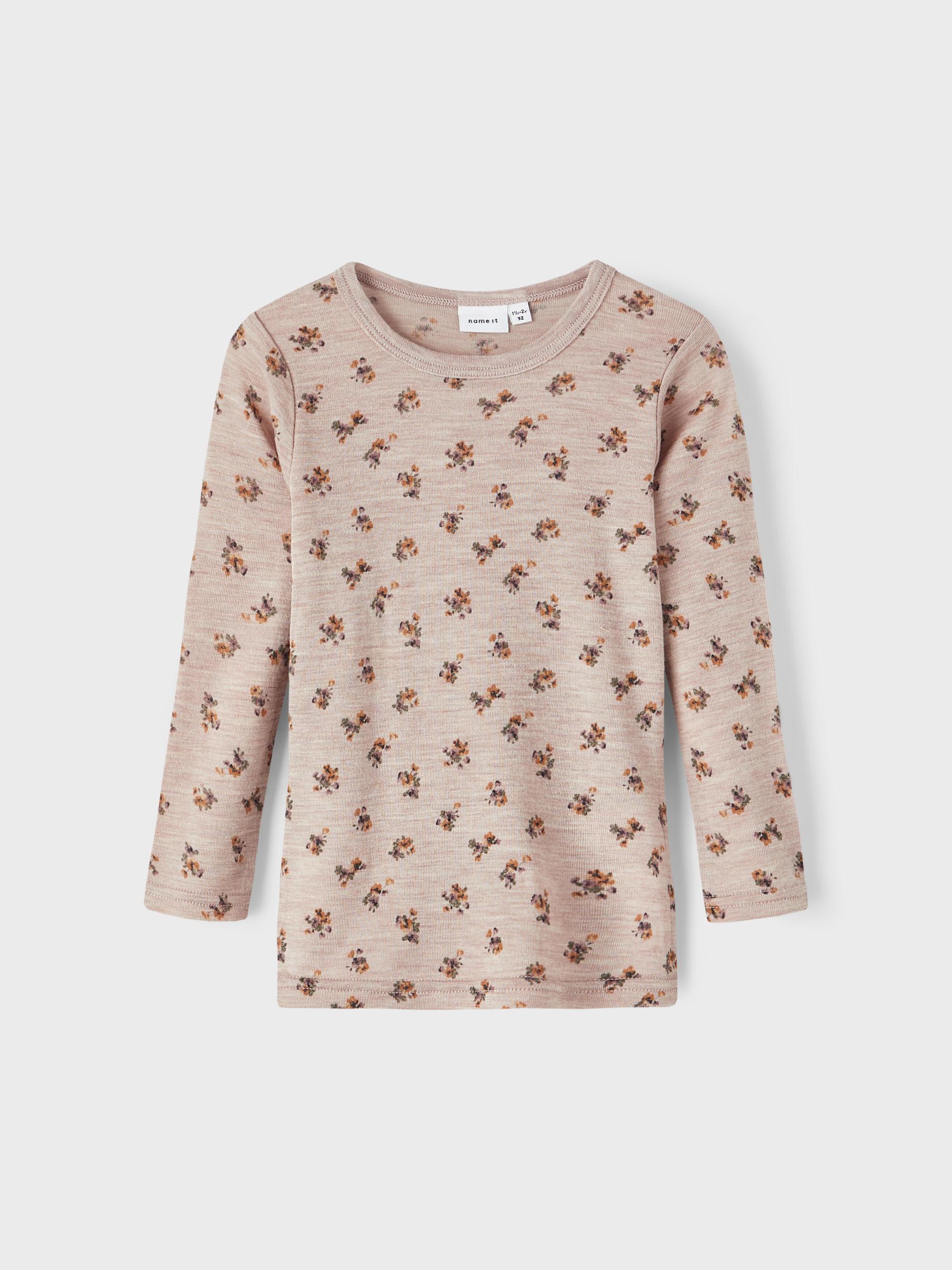 Barns beige langermet topp med lite blomstertrykk, forfra.