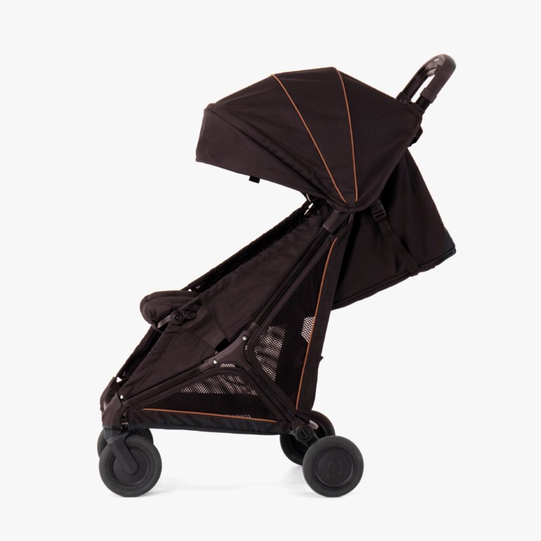 Sideutsikt av en mørkbrun barnevogn med uttrekkbart solskjerm, nettingpaneler og fire svarte hjul.