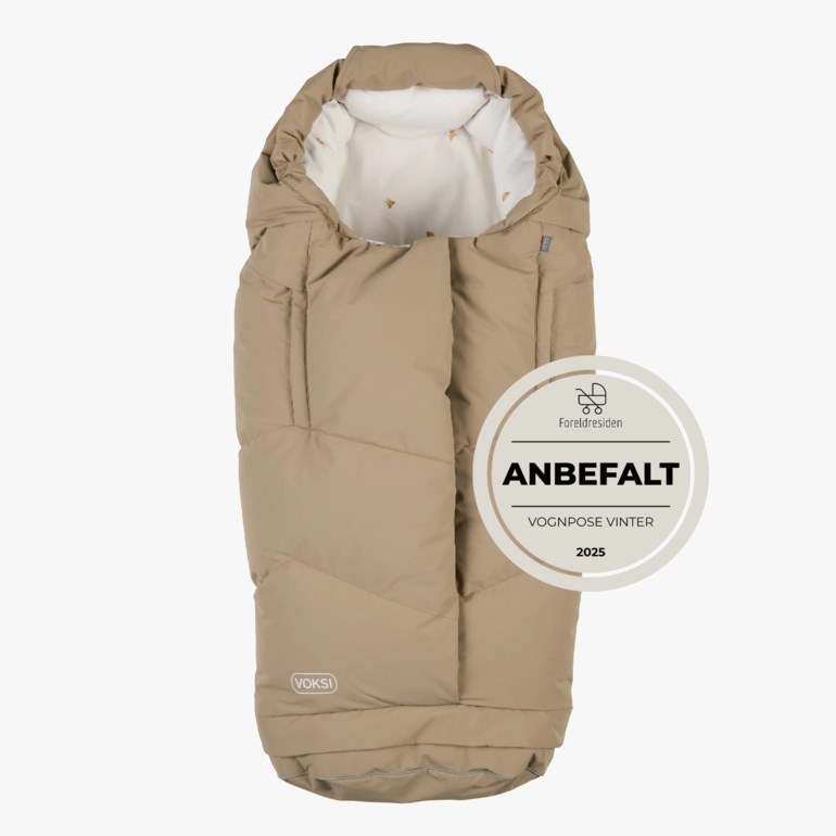 Beige polstret vognpose med hette, hvitt mønstret fôr og et anbefalingsmerke.