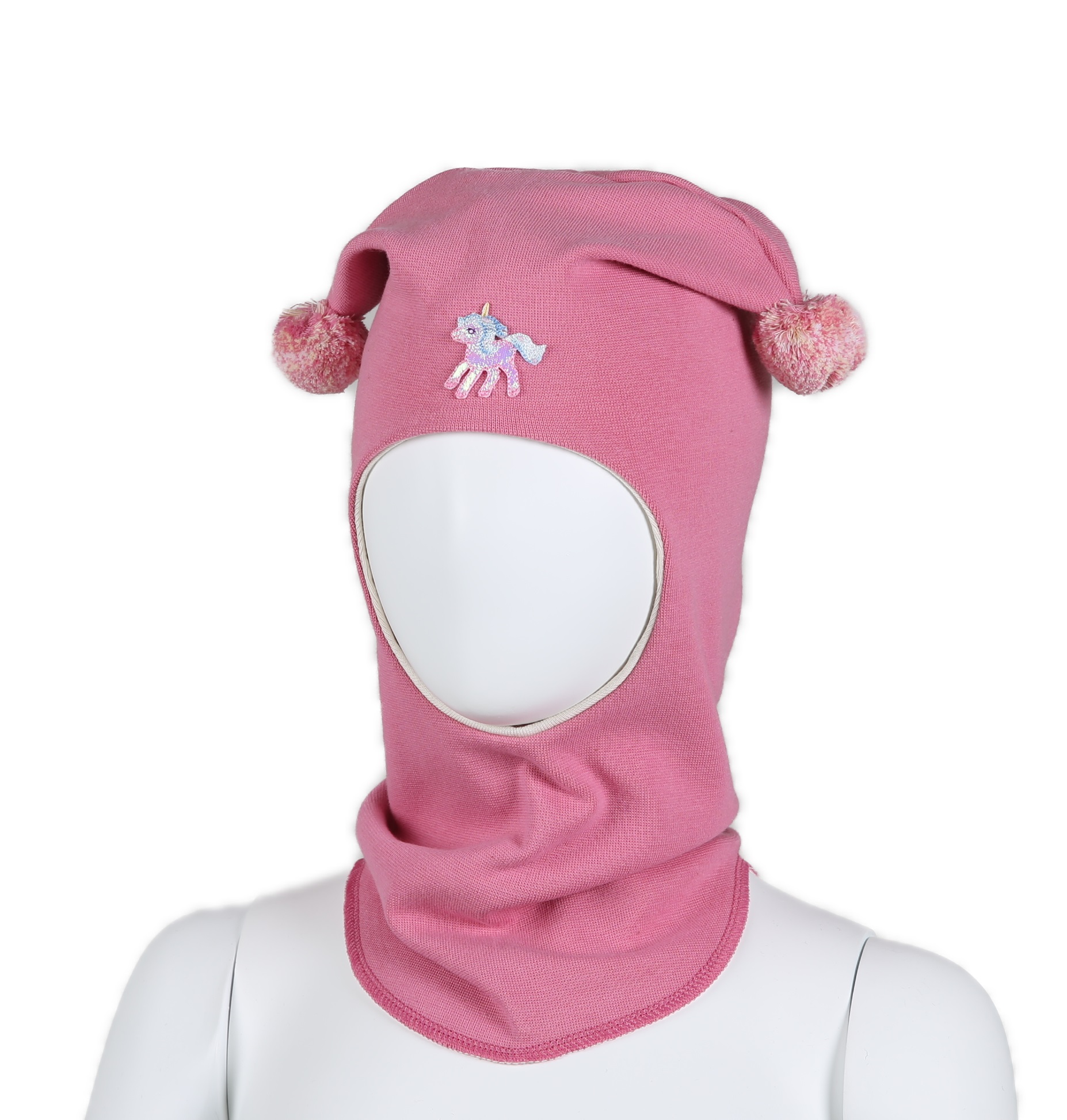 Rosa barnebalaklava med et enhjørningsmerke og to dusker, sett forfra på en utstillingsdukke.