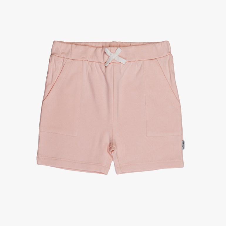 Barns lyse rosa jersey-shorts med elastisk midje, dekorativ hvit sløyfe og lommer, forfra.