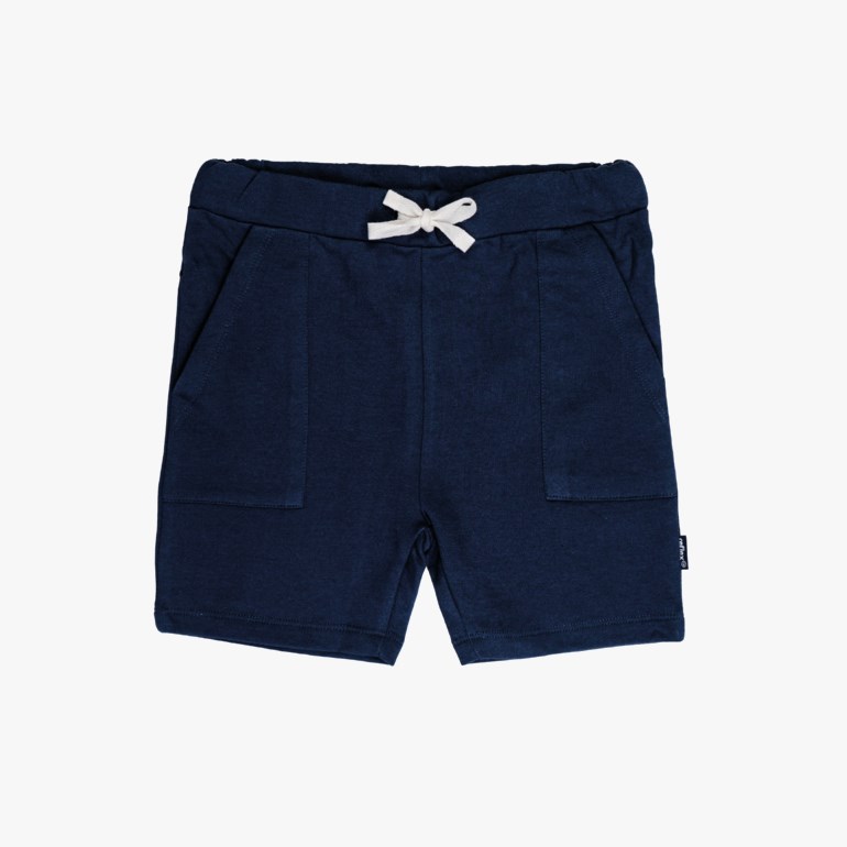 Mørkeblå jersey shorts for barn med hvit dekorativ sløyfe ved snøring i midjen og to frontlommer.