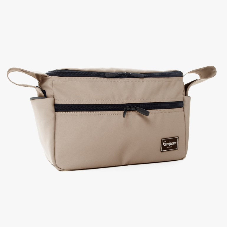 Frontvisning av en rektangulær beige veske med svarte glidelåser på topp og front, og sideløkker.