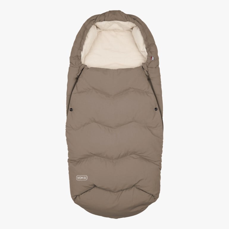 En brun polstret vognpose med kremfarget foring, hette og snorer på sidene, forfra.