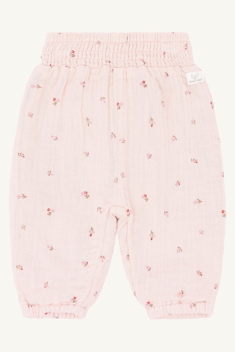 Frontutsikt lys rosa babybukse med elastisk midje, elastiske mansjetter og et lite blomstertrykk.