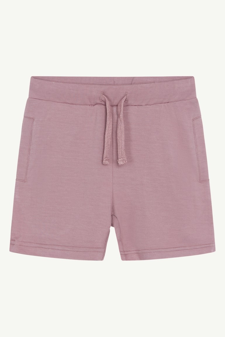 Frontvisning av støvrosa jersey shorts med elastisk snøring i midjen og sidelommer.