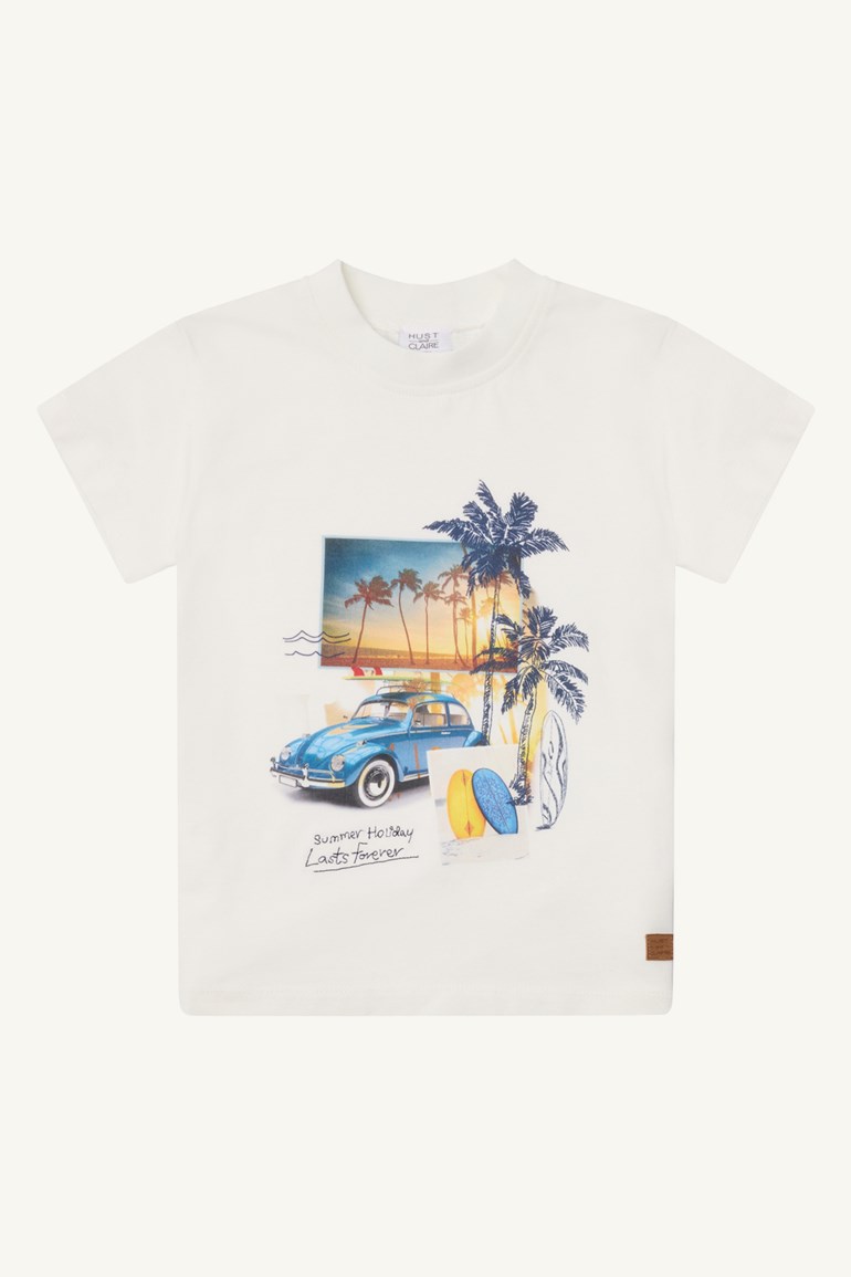 Hvit barneskjorte med grafisk trykk som viser en blå veteranbil, palmer og surfebrett på forsiden.
