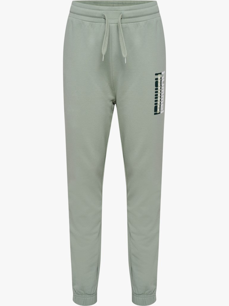Lysegrønne joggebukser med snøring i livet, elastiske mansjetter og en vertikal Hummel-logo på høyre lår.