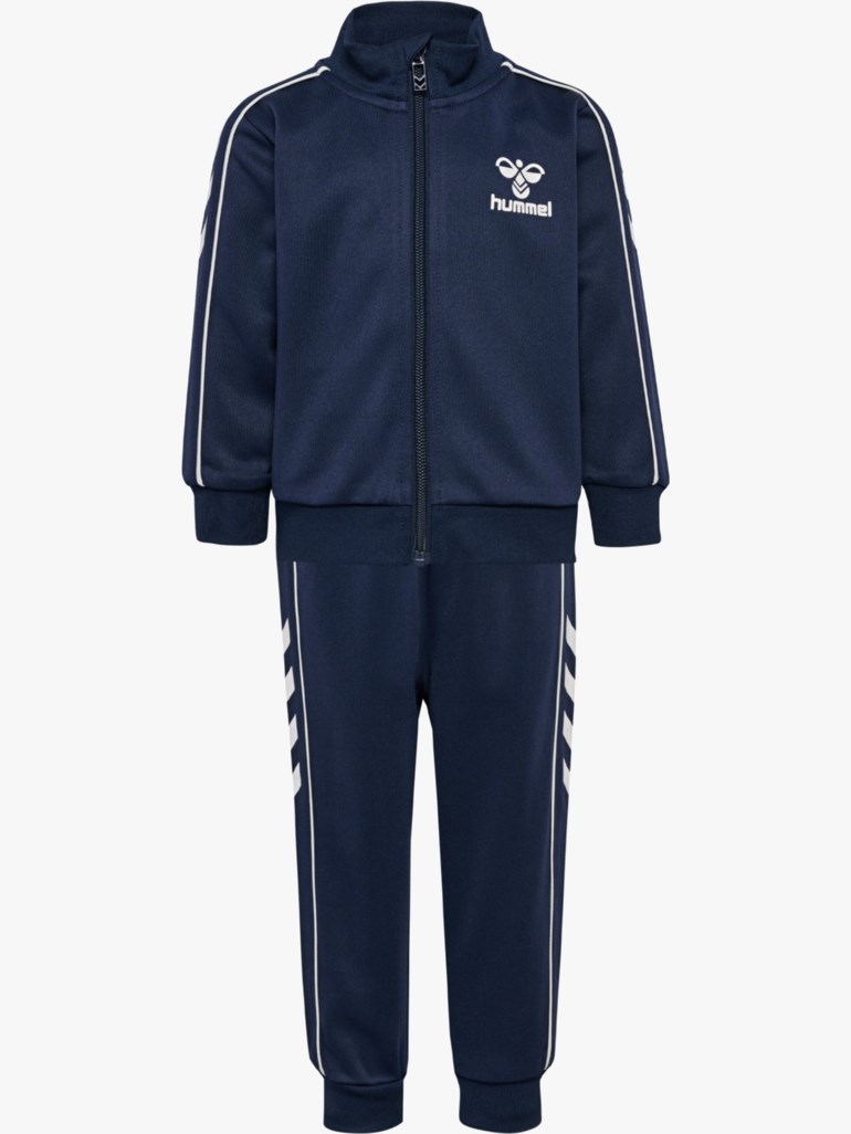 Mørkeblå treningsdress for barn med full glidelås, hvit logo på jakken og hvite striper på buksene.