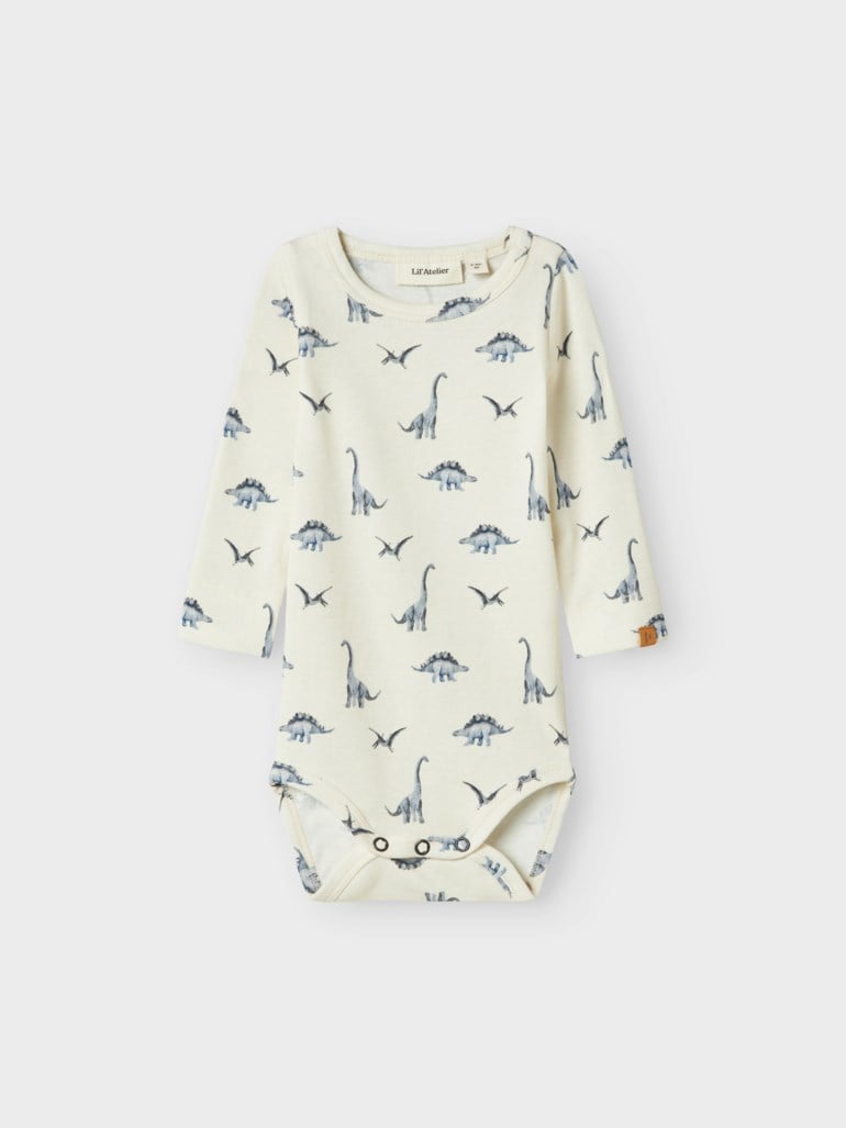 Babybody i kremhvit med lang erm, blått dinosaurmønster og trykknapper i skrittet.