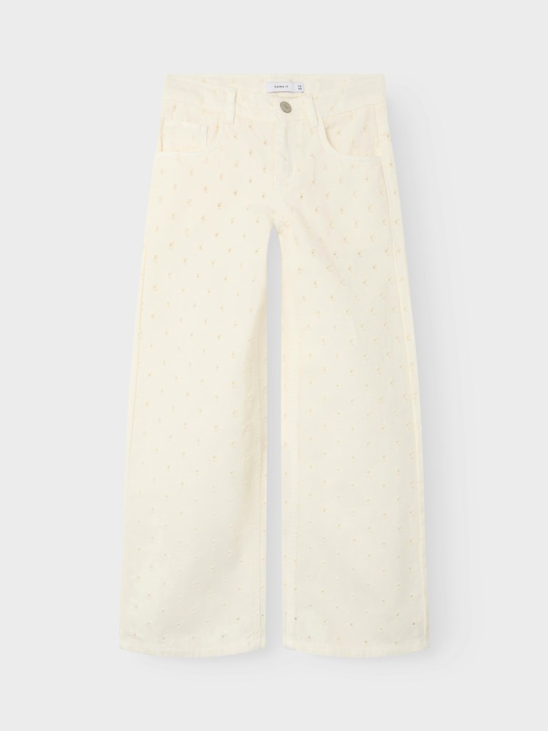 Forfra, kremhvite vide jeans med knappelukking og et diskret prikkete mønster overalt.