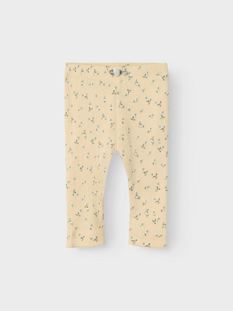 Babyens lysgule ribbestrikkede leggings med hvitt blomstermønster, liten sløyfe og volangkanter.