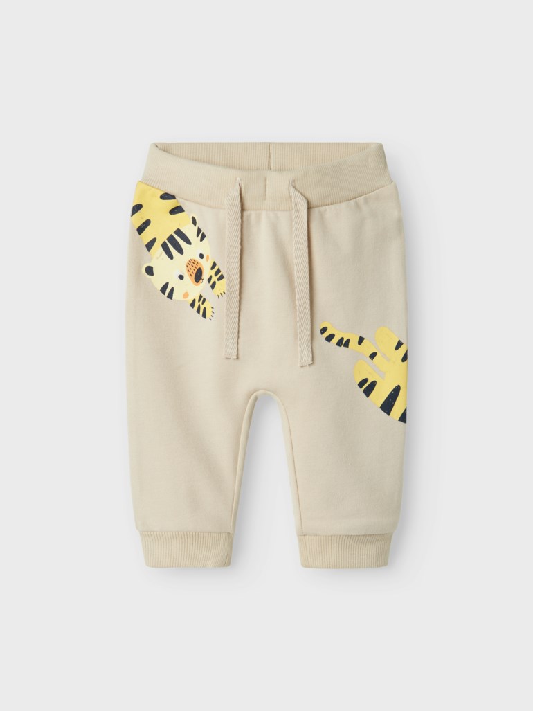 Babys beige joggebukse med tigeransikt på venstre ben og tigerhale på høyre.