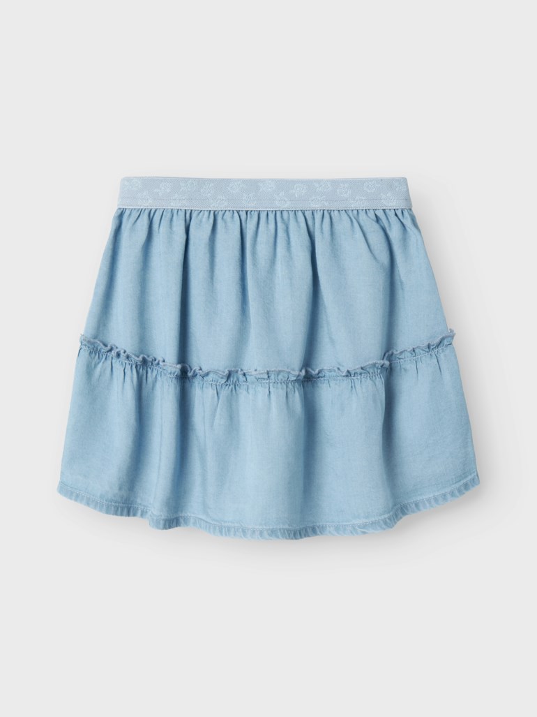 Lys blå kapped denimskjørt med volangkant og mønstret elastisk linning, forfra.