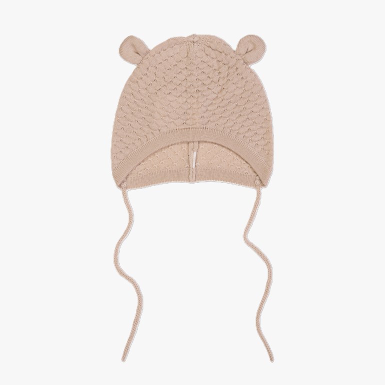 Beige strikket babykyse med bjørneører, mønster og knytebånd, forfra.