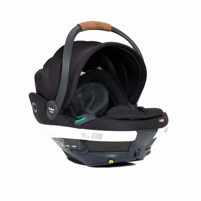 Svart babybilstol med mørkegrått håndtak og brunt grep, festet til en hvit og mørkegrå ISOFIX-base.