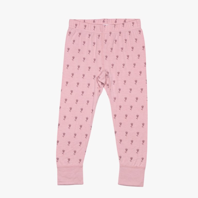 Rosa barneleggings med mørkrosa gjentatt blomstermønster og mansjetter ved anklene, forfra.