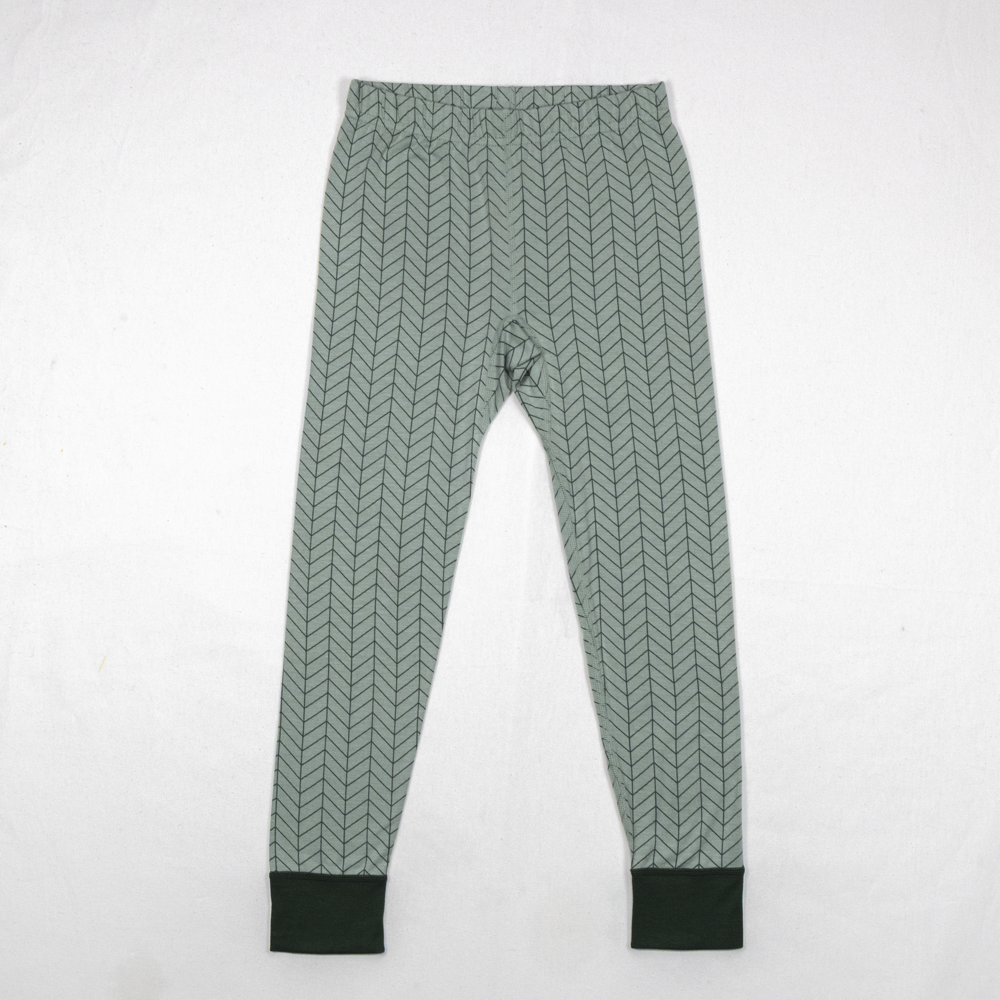 Barns salviegrønne fiskebeinsmønstrede leggings med mørkegrønne mansjetter.