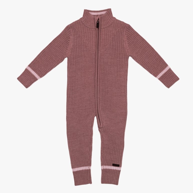 Strikket støvrosa babyheldress med glidelås foran, høy krage og lyserosa stripete ribbemansjetter.